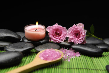 Pink rose and zen stones with herbal salt in spoon with candle