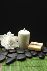 Fototapeta na wymiar Gardenia i kamienie z mydłem i świeca na zielony mat