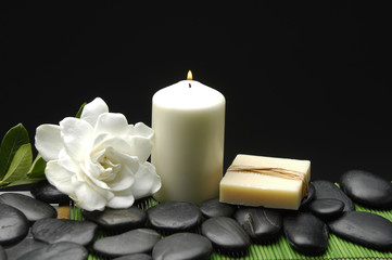 Fototapeta na wymiar Gardenia i kamienie z świec i mydła na zielony mat