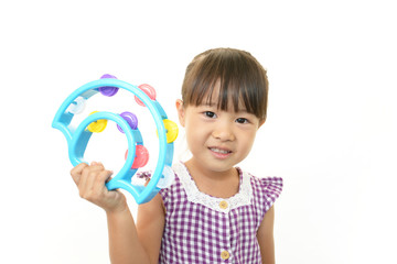 おもちゃの楽器を持ち微笑む女の子