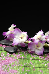 pink branch orchid with zen stone and pile of salt on mat