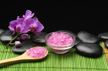 salt in wooden spoon and orchid on green mat