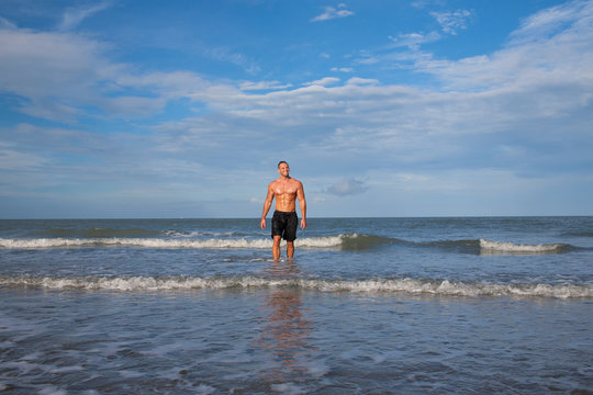 Strong young man portrait at the beach