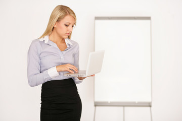 Junge Frau mit Laptop und Flipchart