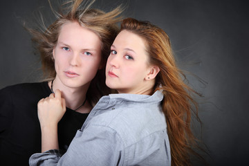 brown hair woman in shirt hug long hair boy in photo studio