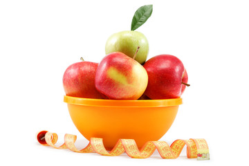 Fresh apples in a bowl and measuring tape isolated on white back