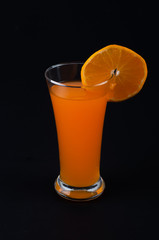 Orange juice and slices of orange  on black background