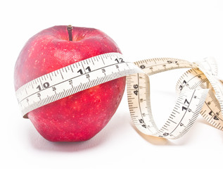 Red apple and measure tape isolated on white background.
