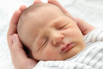 A beautiful sleeping baby in hands