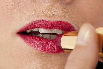 Naklejka premium Applying lipstick