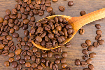 spoon with coffee beans on wooden background