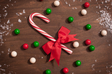 Christmas candy cane with white, green and red gumballs in snow
