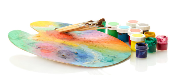 wooden art palette with paint and brushes isolated on white