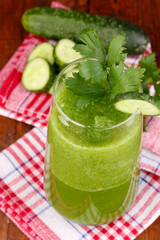 Glass of cucumber juice on wooden table