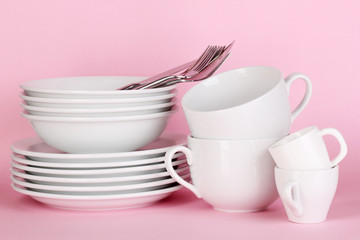 Fototapeta na wymiar Clean white dishes on pink background
