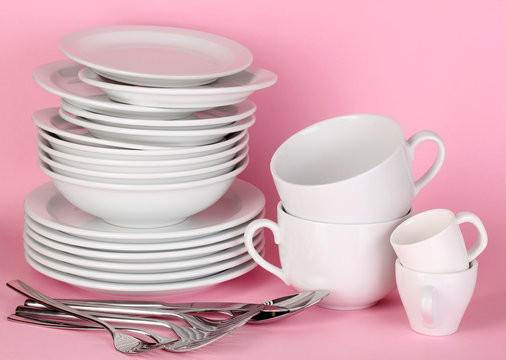 Clean white dishes on pink background