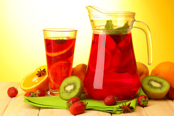 sangria in jar and glass with fruits,
