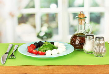 cheese mozzarella with vegetables in the plate with fork and