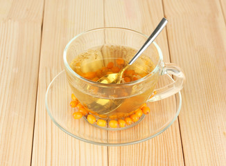 buckthorn broth in a glass cup on wooden background close-up