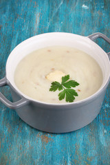 Mashed potatoes in saucepan on blue wooden table