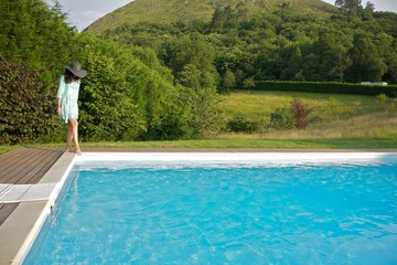 woman test water on pool corner