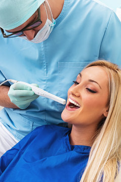 Dentist examines teeth of the patient with teeth-camera