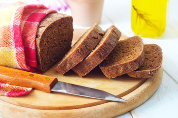 Fresh bread and knife on the wooden board