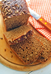 Fresh bread and knife on the wooden board