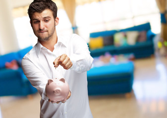 A Businessman Putting A Coin Into A Pink Piggy Bank