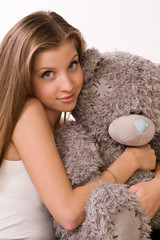 Sensuality girl with teddy-bear sitting on a sofa