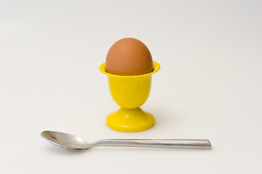 Yellow cup with egg and spoon