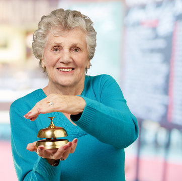 Happy Mature Woman While Holding Bell