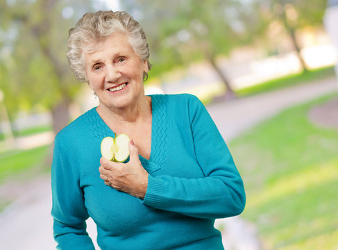 Portrait Of Happy Mature Woman While Holding Apple