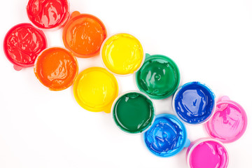 motley paints on the white background. paints arranged as rainbo