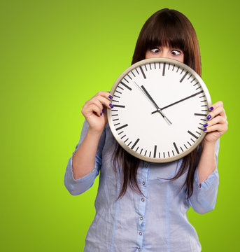 Woman Holding Clock With Squinted Eyes