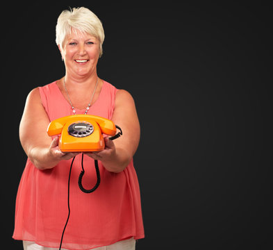 Portrait Of A Senior Woman Holding A Retro Phone