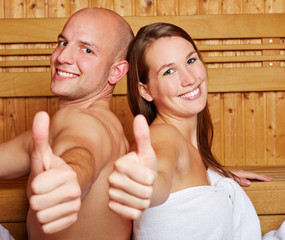 Paar zeigt Daumen hoch in Sauna