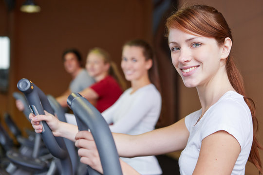 Gruppe trainiert im Fitnesscenter am Crosstrainer