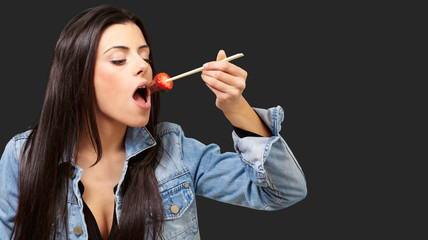 Obraz premium Portrait Of A Female Eating Strawberry With Chocolate Sauce