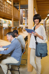 Obraz premium Woman with tablet pc in library