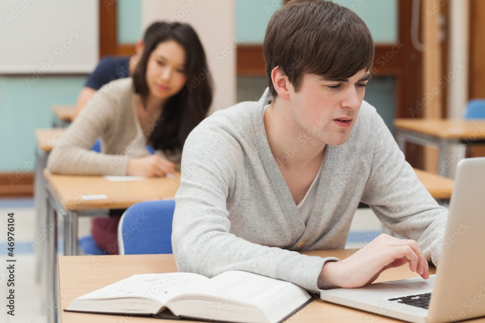 Poster student sitting at the classroom while typing
