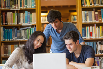 Students watching something on laptop in library