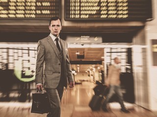 Man in classic grey suit with briefcase in airport