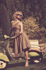 Frau im Retro-Kleid mit einem Roller © Nejron Photo