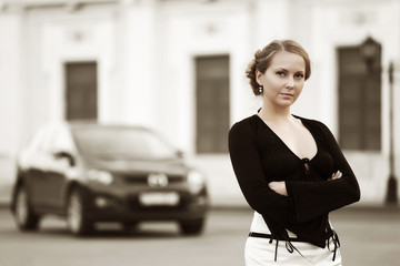 Young woman against a car parking