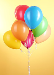 Colorful balloons on yellow background