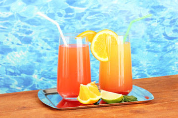 Two cocktails on tray on blue background