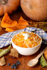 Useful pumpkin porridge in white plate on wooden table close-up