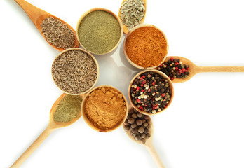 wooden bowls and spoons with spices isolated on white