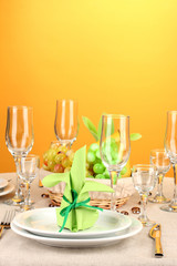 Table setting in green and yellow tones on color  background